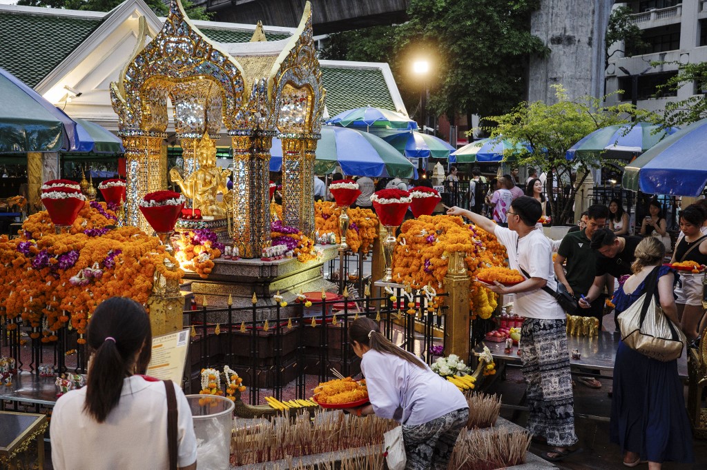 游客周二在曼谷四面佛前祈祷并供奉祭品。(图取自法新社) 游客周二在曼谷四面佛前祈祷并供奉祭品。(图取自法新社)