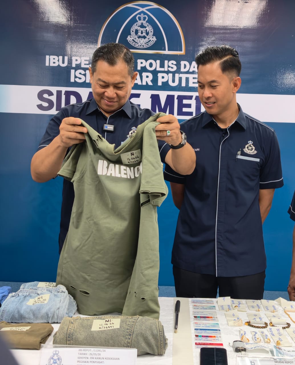 拉哈曼查看警方起获的嫌犯衣服。右为莫哈末再利。