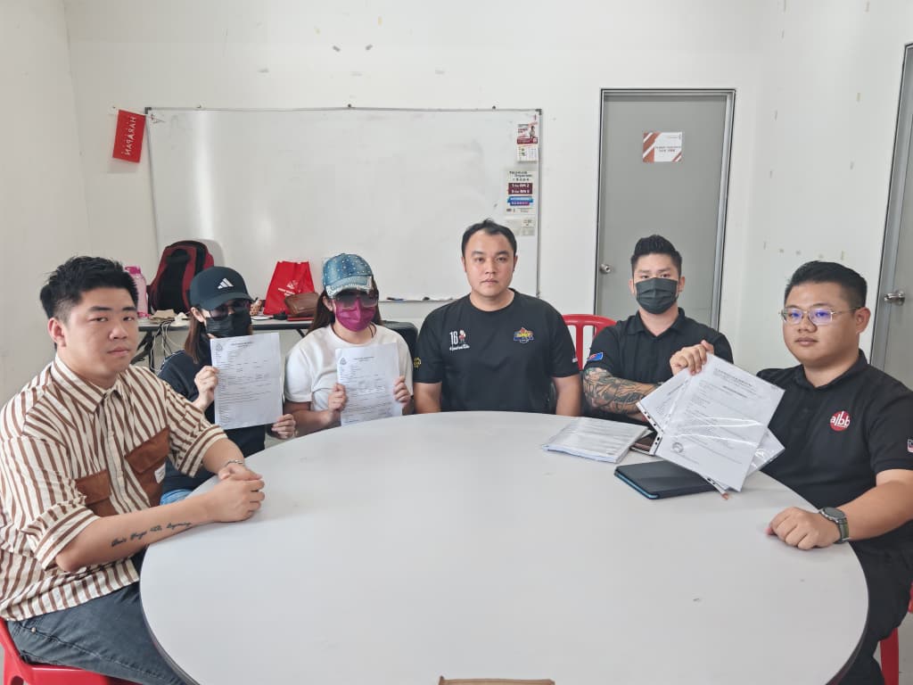 投资者出示报案书,坐者左起为刘先生、莫小姐、刘小姐郭子仪、陈先生和杨先生。 投资者出示报案书,坐者左起为刘先生、莫小姐、刘小姐郭子仪、陈先生和杨先生。